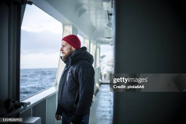 man on a vessel sailing the sea - ferry stock pictures, royalty-free photos & images