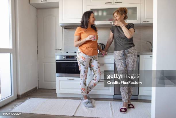 台所で先輩女性とコーヒーを飲む介護ホームケア - look alike ストックフォトと画像