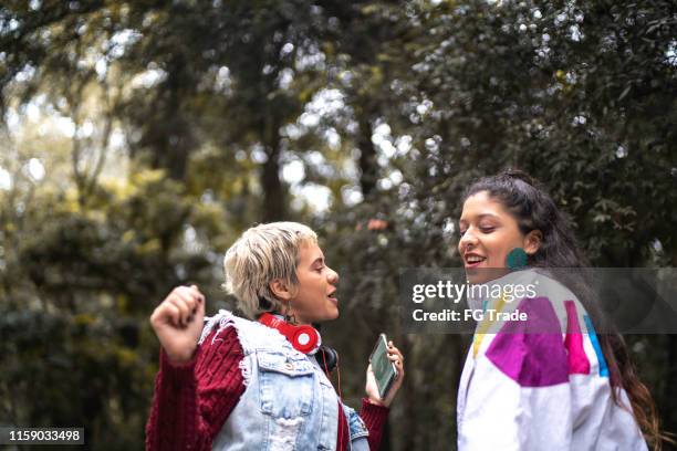 latin young women dancing in the park - teen lesbians stock pictures, royalty-free photos & images