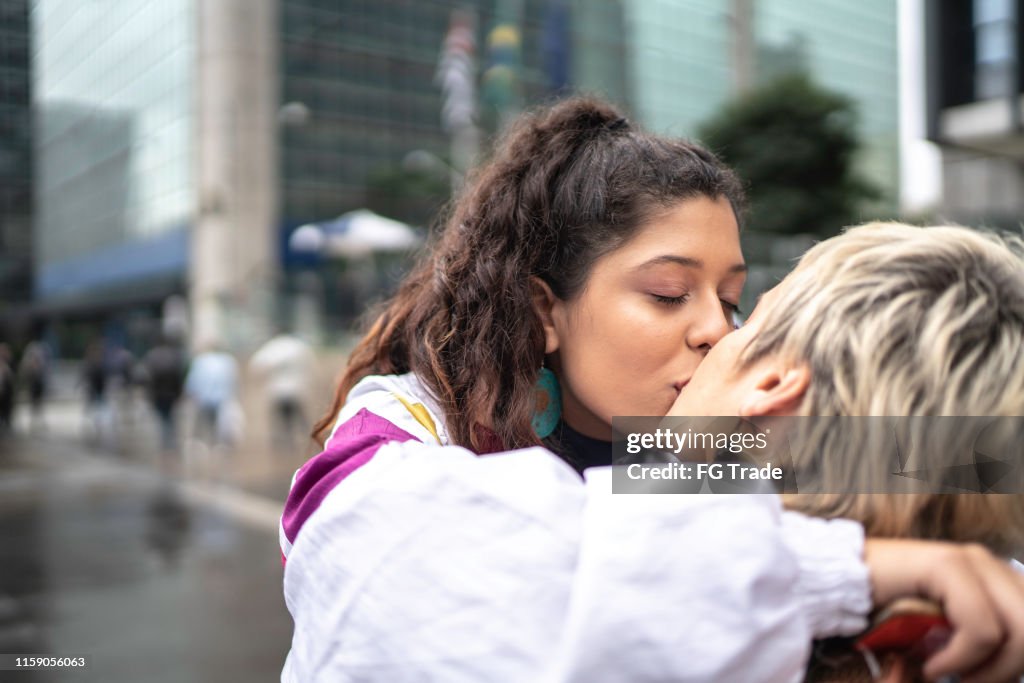 Couple kissing while walking in the street