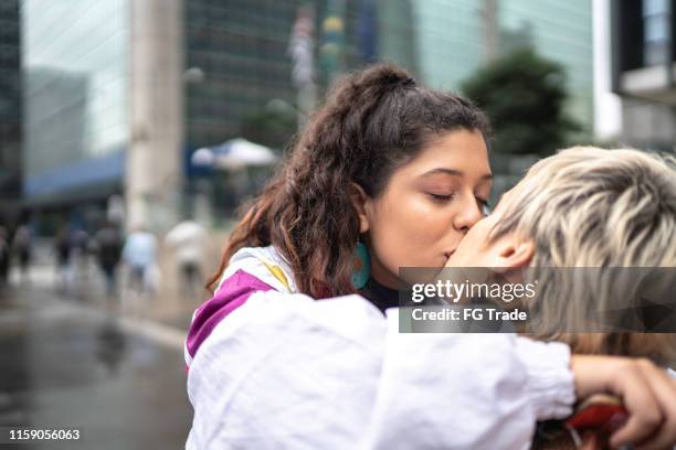 couple kissing while walking in the street - teen lesbians stock pictures, royalty-free photos & images