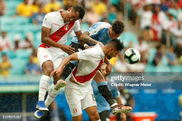 Jose Gimenez of Uruguay heads the ball against Renato Tapia and Carlos Zambrano of Peru during the Copa America Brazil 2019 quarterfinal match...