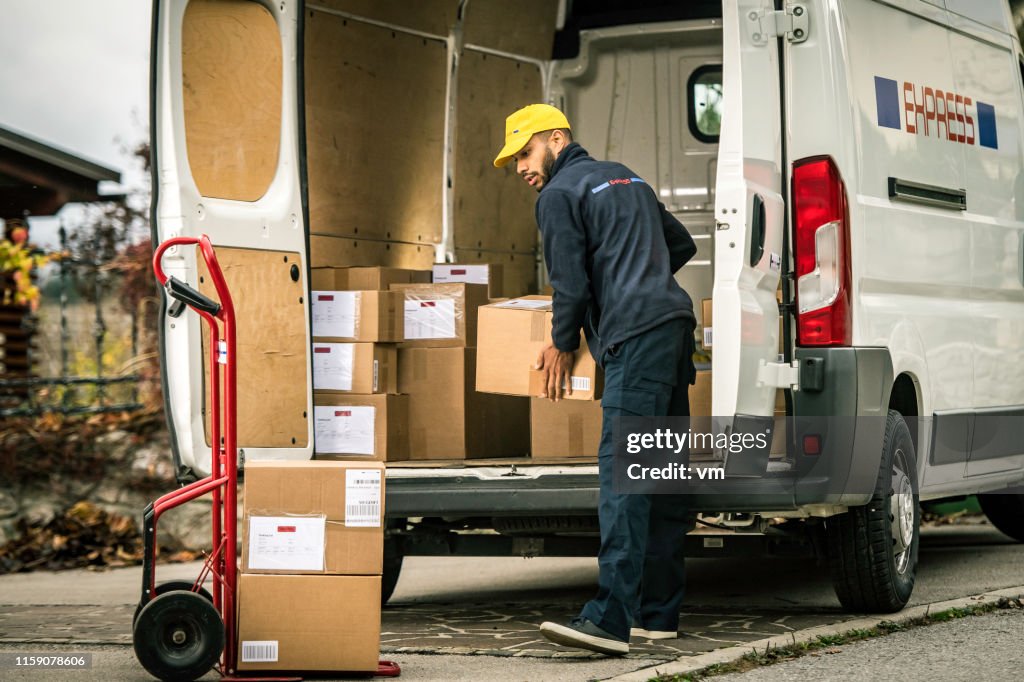 Delivery man loading boxes on a push cart