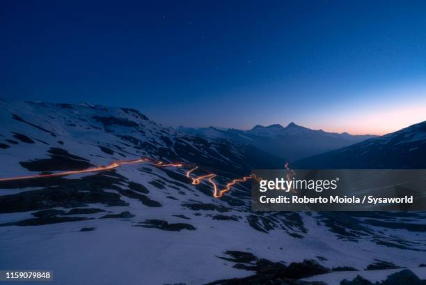 car trail lights on bends of splugen pass, switzerland - mountain pass stock pictures, royalty-free photos & images