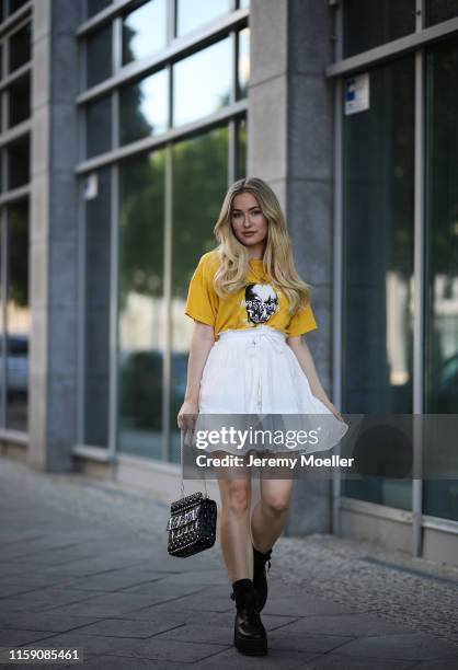 Sonny Loops wearing a Maison Valentino bag, wrstbhvr shirt, About You skirt and Asos boots on June 29, 2019 in Berlin, Germany.