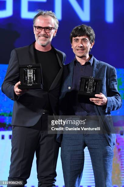 Fabrizio Ferracane and Luigi Lo Cascio pose with awards on stage at the Nastri D'Argento awards ceremony in Taormina on June 29, 2019 in Taormina,...