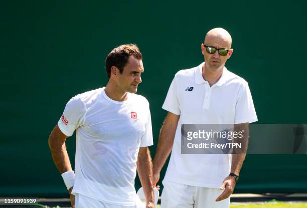 Roger Federer of Switzerland and his coach Ivan Ljubicic during a practice session before the start of The Championships - Wimbledon 2019 at All...
