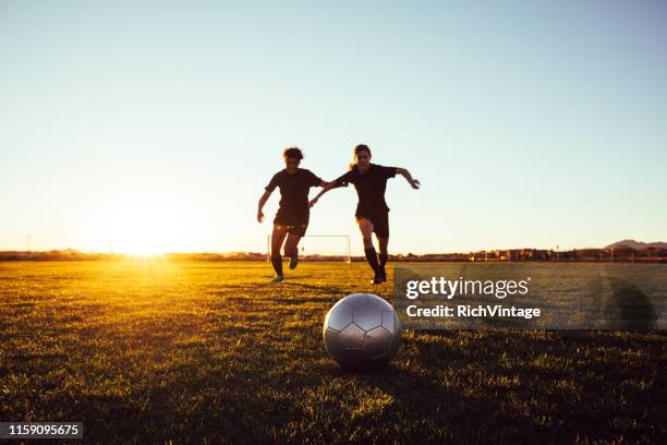 female soccer players battle for ball - high school football stock pictures, royalty-free photos & images