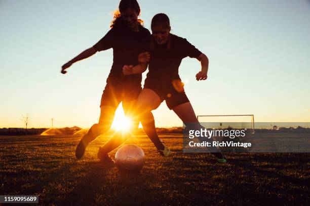 female soccer players battle for ball - football player silhouette stock pictures, royalty-free photos & images
