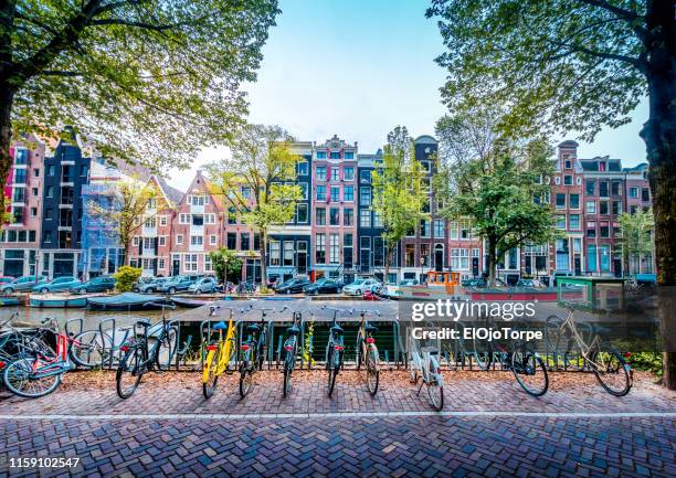 bicycles by the amstel river, amsterdam city, netherlands - estrecho fotografías e imágenes de stock