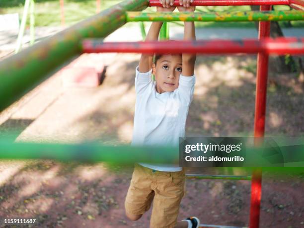 determined boy on the monkey bars - boy on monkey bars stock pictures, royalty-free photos & images