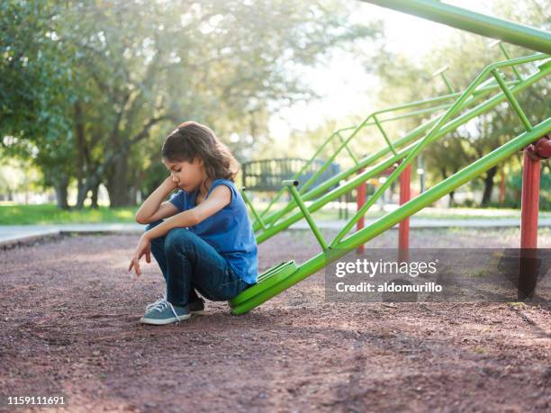 liten sorglig flicka som sitter själv i parken - hot latino girl bildbanksfoton och bilder