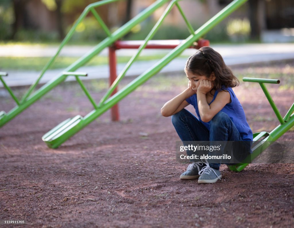 Menina com ninguém para jogar com no totter do Teeter