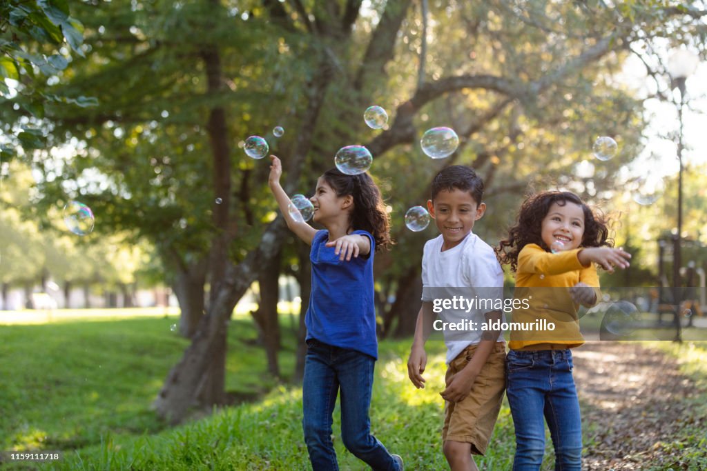 Children playing with bubbles outdoors