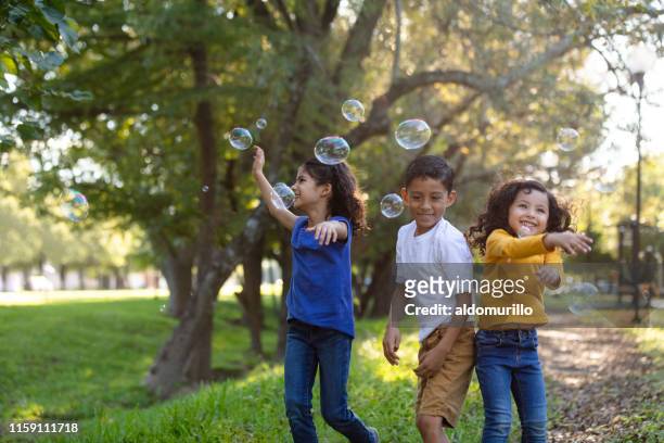 children playing with bubbles outdoors - children only stock pictures, royalty-free photos & images