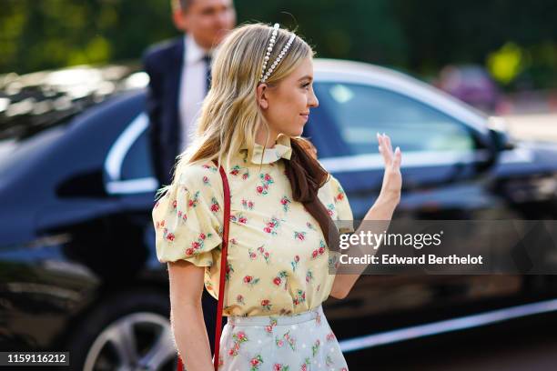 Sydney Sweeney wears a headband, a floral print yellow ruffled t-shirt, a pale blue floral print skirt, outside Miu Miu Club 2020, on June 29, 2019...