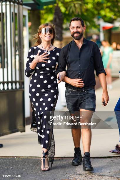 Carine Roitfeld wears sunglasses, a black and white polka dots dress, earrings, a necklace, outside Miu Miu Club 2020, on June 29, 2019 in Paris,...