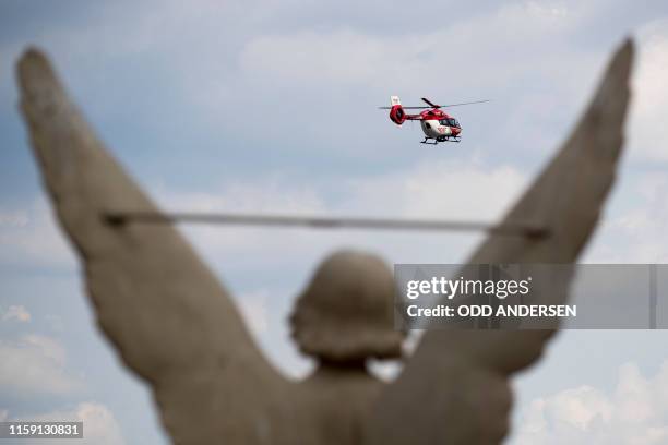 German Air Rescue helicopter is framed by an angel statue on the St. Nicolas' church as it takes off from a landing pad at the Ernst Von Bergmann...