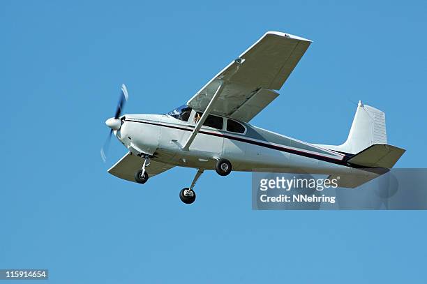 private airplane cessna 182 flying in clear blue sky - propellervliegtuig stockfoto's en -beelden