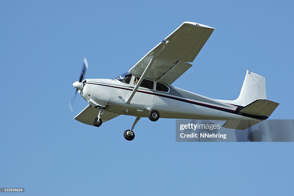 Private airplane Cessna 182 flying in clear blue sky