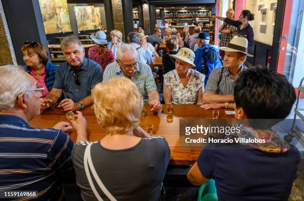 Tourists sit in front of glasses of Madeira wine ready for tasting at Blandy's Wine Lodge on June 27, 2019 in Funchal, Portugal. The Blandy family is...
