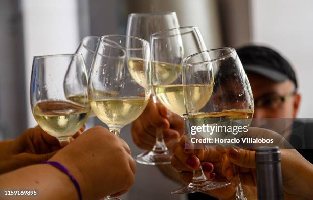 Visitors toast with glasses of Barbusano white wine on June 27, 2019 in Funchal, Portugal. Madeira Island is one of Europe's most sought after...