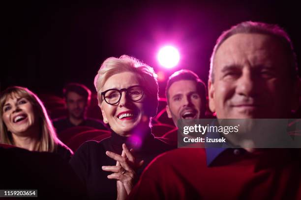 seniorin genießt es, einen film im theater zu sehen - kinobesucher stock-fotos und bilder