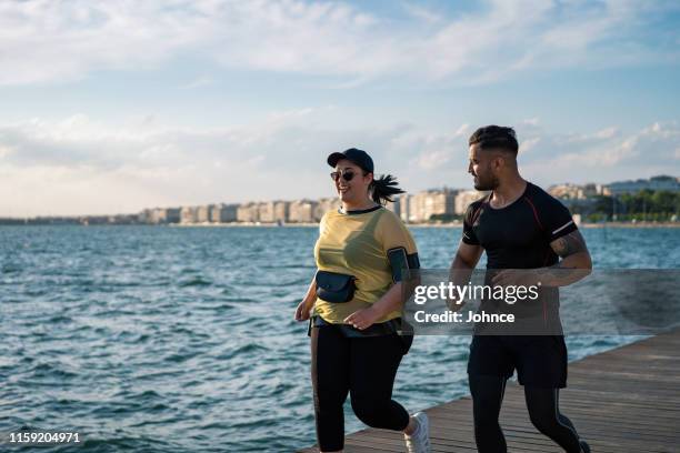 overgewicht vrouw joggen met trainer - fat asian man stockfoto's en -beelden