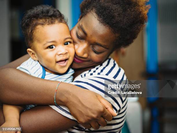 afrikanische mutter mit gemischtem rassensohn - black man holding baby stock-fotos und bilder