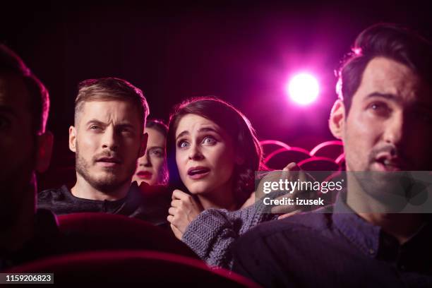 paar kijken naar een horrorfilm op theater - scary movie stockfoto's en -beelden