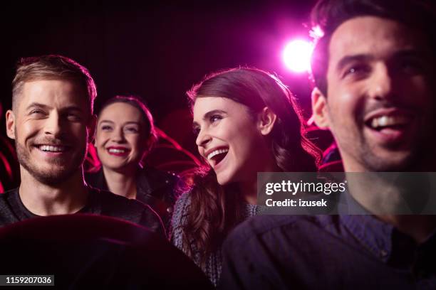 glückliche freunde sehen film im theater - publikum lachen stock-fotos und bilder