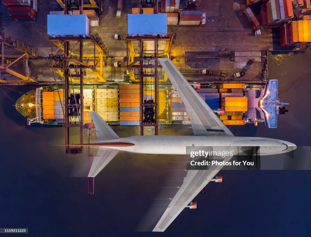 Aerial view/Cargo ships are discharging cargo in the container at the port and transport by air frieght./top view