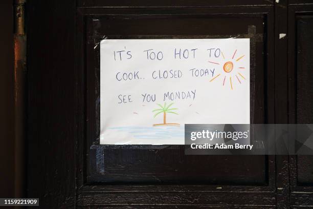 Restaurant's sign reads 'It's too hot to cook. Closed today. See you Monday.' during a continued heatwave, on June 30, 2019 in Berlin, Germany....