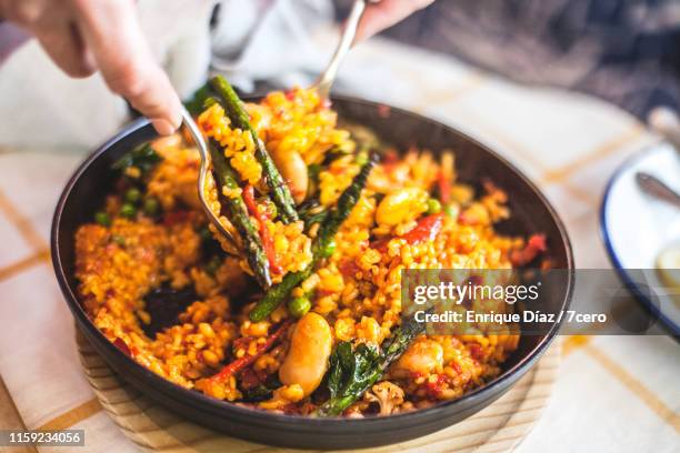 mixing up the vegetable paella - mediterranean food stockfoto's en -beelden