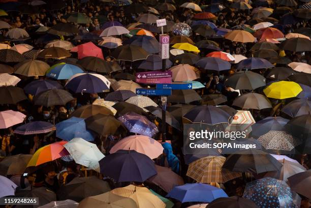 Protesters use umbrellas due to heavy rain during the rally. People gathered for a demonstration by civil servants at Chater Garden in the financial...