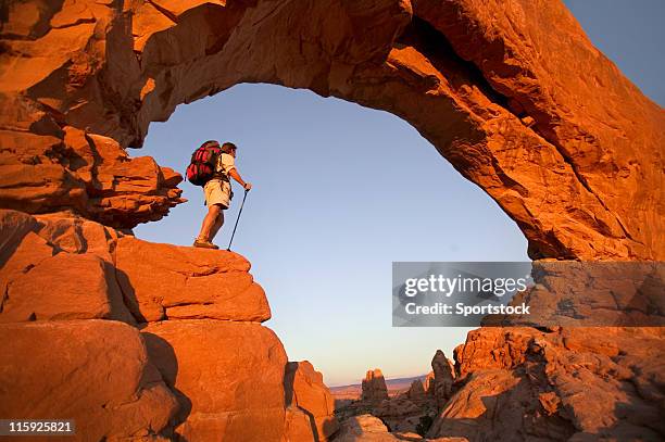 hiker in rock arch looking at view - hiking utah stock pictures, royalty-free photos & images