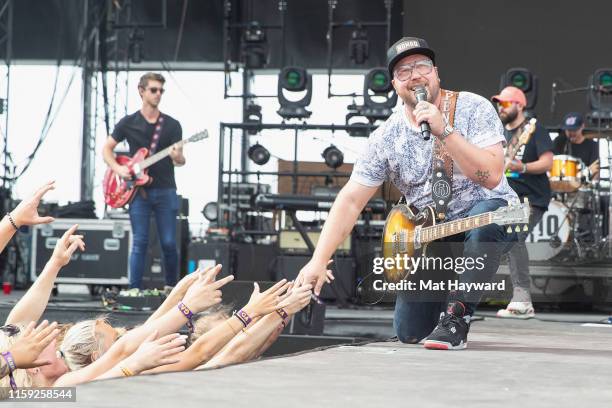 Singer Mitchell Tenpenny reaches for fans while performing on stage during the Watershed Country Music Festival at the Gorge Amphitheatre on August...