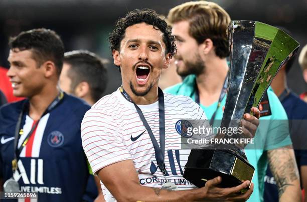 Paris Saint-Germain's Brazilian defender Marquinhos poses with a trophy after winning the French Trophy of Champions football match between Paris...
