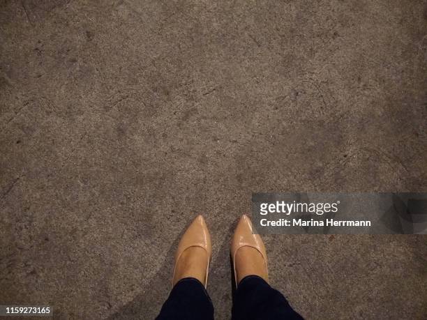 lower section of female leg on gray sidewalk - lower foto e immagini stock