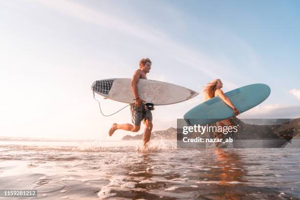 surfisti in spiaggia. - waves crashing foto e immagini stock