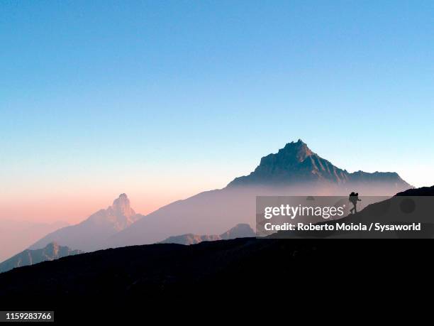 hiker at sunrise, gran paradiso national park, aosta valley - scène tranquille brume photos et images de collection