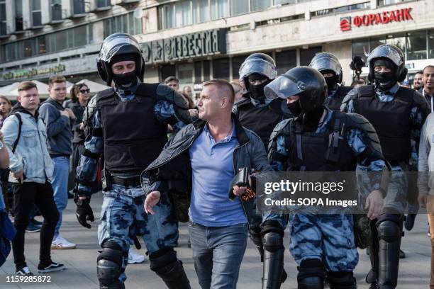 Police officers detain a man during an unsanctioned rally in the centre of Moscow, Russia. Moscow police detained more than 300 people who were...