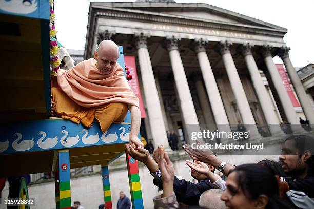 Devotee of the Hare Krishna faith distributes food gifts from a Chariot during the festival of Rathayatra on June 12, 2011 in London, England....