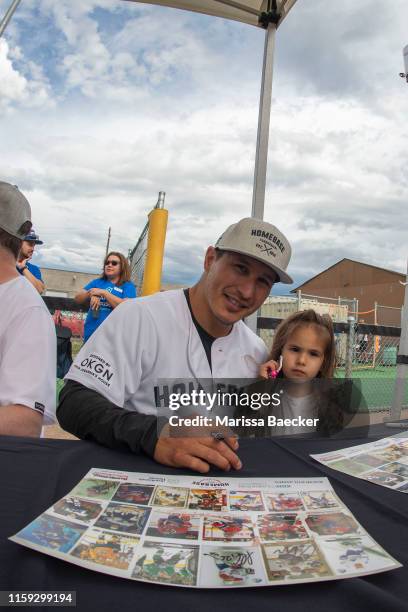 Former NHL player Jordin Tootoo sings autographs for a young fan prior to the opening celebrity game of the Home Base Slo-Pitch Tournament fundraiser...