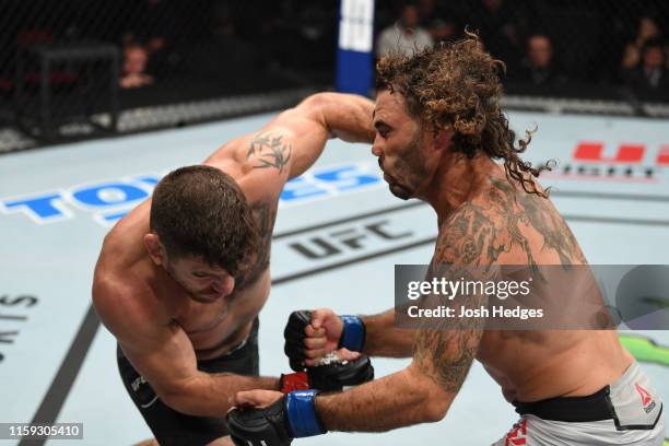 Jim Miller punches Clay Guida in their lightweight bout during the UFC Fight Night event at the Prudential Center on August 3, 2019 in Newark, New...