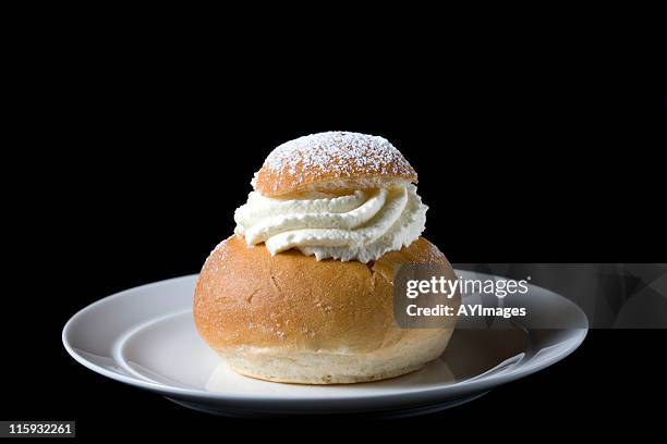 swedish cream bun (semla) on black background - shrovetide stockfoto's en -beelden