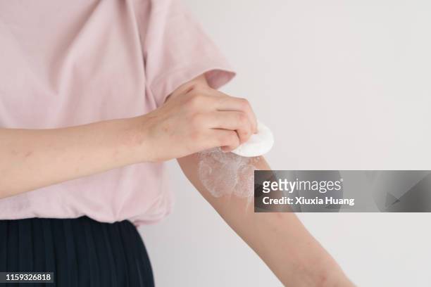 asian female using talcum powder on arm - powder puff stock pictures, royalty-free photos & images