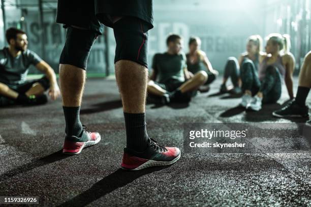 entrenador irreconocible en un entrenamiento deportivo con sus atletas en un gimnasio. - crossfit training fotografías e imágenes de stock