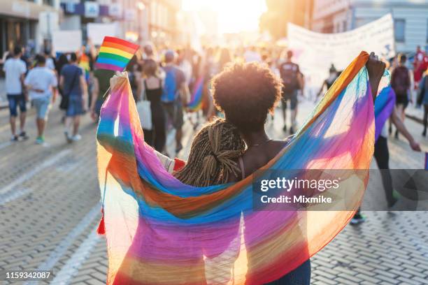 multikulturelles weibliches paar zu fuß mit dem stolz festival in sofia - pride fest stock-fotos und bilder