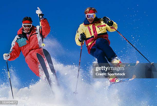 two snow skiers jumping against blue sky - freestyle skiing stockfoto's en -beelden